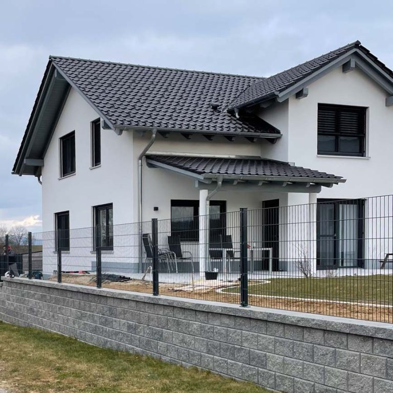 Modernes Wohnhaus mit Gartenzaun.